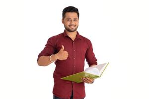 Young happy man holding and posing with the book on white background. photo