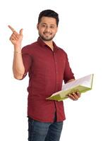 Young happy man holding and posing with the book on white background. photo