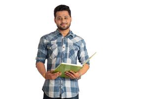 Young happy man holding and posing with the book on white background. photo