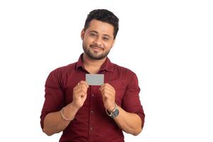 Young smiling handsome man posing with a credit or debit card on white background. photo