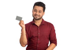 Young smiling handsome man posing with a credit or debit card on white background. photo