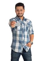 Young smiling handsome man posing with a credit or debit card on white background. photo