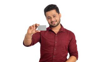 Young smiling handsome man posing with a credit or debit card on white background. photo
