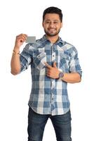 Young smiling handsome man posing with a credit or debit card on white background. photo