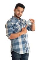 Young smiling handsome man posing with a credit or debit card on white background. photo