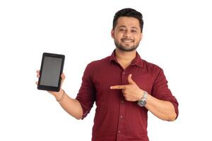 Young handsome man, businessman showing a blank screen of a smartphone or mobile or tablet phone on white background photo