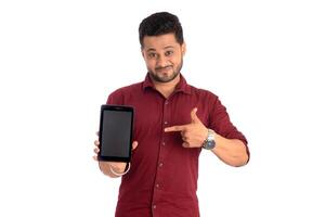 Young handsome man, businessman showing a blank screen of a smartphone or mobile or tablet phone on white background photo