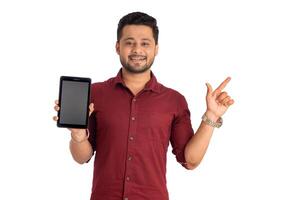 Young handsome man, businessman showing a blank screen of a smartphone or mobile or tablet phone on white background photo