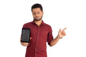 Young handsome man, businessman showing a blank screen of a smartphone or mobile or tablet phone on white background photo