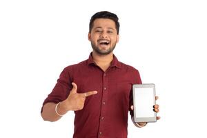 Young handsome man, businessman showing a blank screen of a smartphone or mobile or tablet phone on white background photo