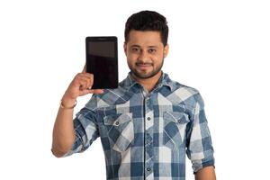 Young handsome man, businessman showing a blank screen of a smartphone or mobile or tablet phone on white background photo