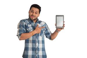 Young handsome man, businessman showing a blank screen of a smartphone or mobile or tablet phone on white background photo