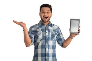 Young handsome man, businessman showing a blank screen of a smartphone or mobile or tablet phone on white background photo