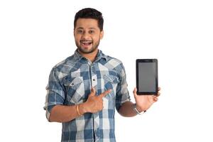 Young handsome man, businessman showing a blank screen of a smartphone or mobile or tablet phone on white background photo