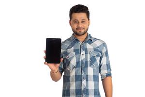 Young handsome man, businessman showing a blank screen of a smartphone or mobile or tablet phone on white background photo