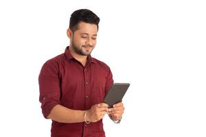Young handsome man holding and using smartphone or mobile or tablet phone on a white background photo