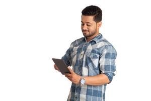 Young handsome man holding and using smartphone or mobile or tablet phone on a white background photo