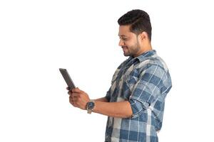 Young handsome man holding and using smartphone or mobile or tablet phone on a white background photo