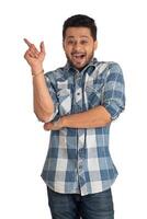 Portrait of a successful cheerful young man pointing and presenting something with hand or finger with a happy smiling face. photo