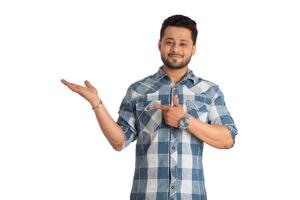 Portrait of a successful cheerful young man holding and presenting something on hand with a happy smiling face. photo