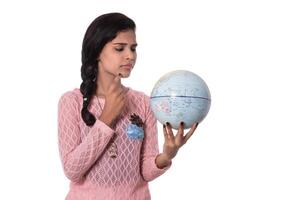 Beautiful Girl holding a world globe isolated on a white background photo