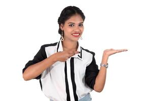 Beautiful girl holding and presenting something in the hand with happy smiling. photo