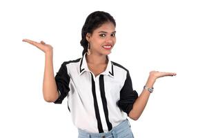 Beautiful girl holding and presenting something in the hand with happy smiling. photo