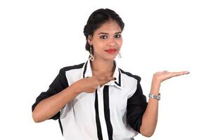 Beautiful girl holding and presenting something in the hand with happy smiling. photo