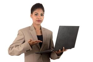 Happy excited business woman holding laptop and pointing on it isolated on a white background photo