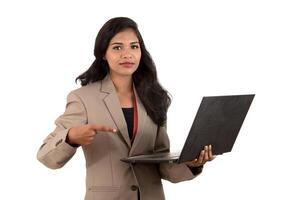 Happy excited business woman holding laptop and pointing on it isolated on a white background photo