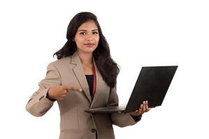 Happy excited business woman holding laptop and pointing on it isolated on a white background photo