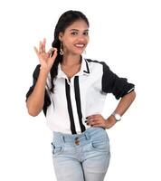 Smiling cheerful girl showing okay sign or thumbs up isolated on white background photo