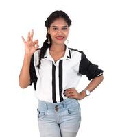 Smiling cheerful girl showing okay sign or thumbs up isolated on white background photo