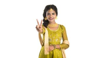 Smiling cheerful girl showing sign isolated on white background photo