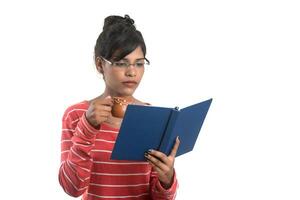 Beautiful young girl with book and cup of coffee posing on a white background. photo