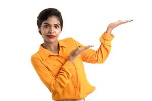 Beautiful girl holding and presenting something in the hand with happy smiling. photo