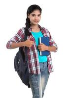 young Indian woman with backpack standing and holding notebooks, posing on a white background. photo
