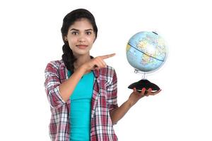 young woman holding the world globe and posing on a white background. photo