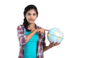 young woman holding the world globe and posing on a white background. photo