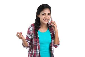 Young Indian girl using a mobile phone or smartphone isolated on a white background photo