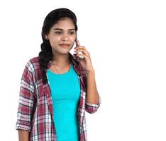 Young Indian girl using a mobile phone or smartphone isolated on a white background photo