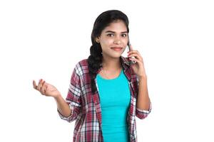 Young Indian girl using a mobile phone or smartphone isolated on a white background photo