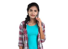 Young Indian girl using a mobile phone or smartphone isolated on a white background photo