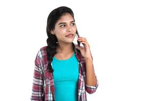 Young Indian girl using a mobile phone or smartphone isolated on a white background photo
