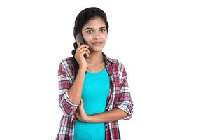 Young Indian girl using a mobile phone or smartphone isolated on a white background photo