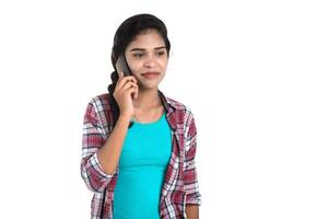 Young Indian girl using a mobile phone or smartphone isolated on a white background photo