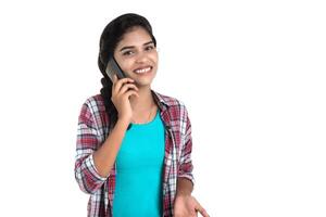 Young Indian girl using a mobile phone or smartphone isolated on a white background photo
