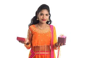 Portrait of young happy smiling Indian Girl holding gift boxes on a white background. photo