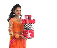 Portrait of young happy smiling Indian Girl holding gift boxes on a white background. photo