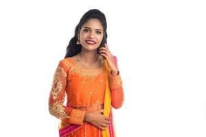 Young Indian traditional girl using a mobile phone or smartphone isolated on a white background photo
